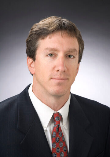 A man in suit and tie with short hair.